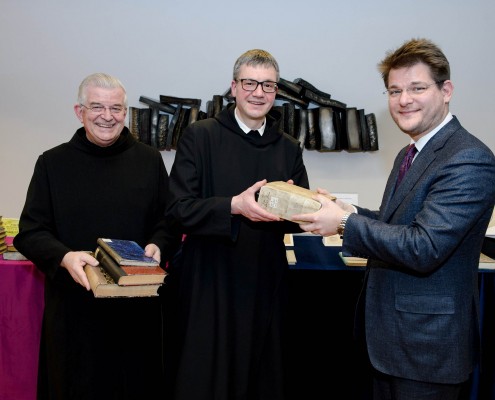 Übergabe der Restitutionsbände an Pater Prior Paulus Kohler OH (Barmherzige Brüder) und Thomas Petutschnig OSB (Benediktiner St. Paul) durch Rektor Oliver Vitouch. Foto: AAU/Thomas Hude