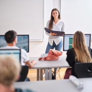 Studierende hält ein Referat vor anderen Studierenden in einem Seminarraum