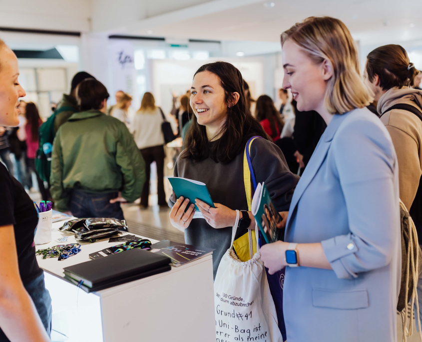 Zwei Studierende werden an einem Stand der connect 2023 beraten.